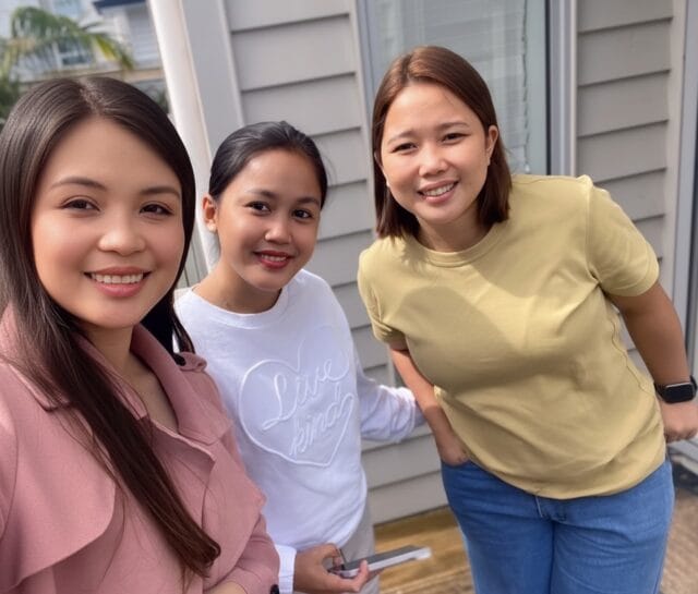 Jeanie - the founder of Jumpstart International, taking a selfie with two successful clients, happy that they are now in New Zealand.