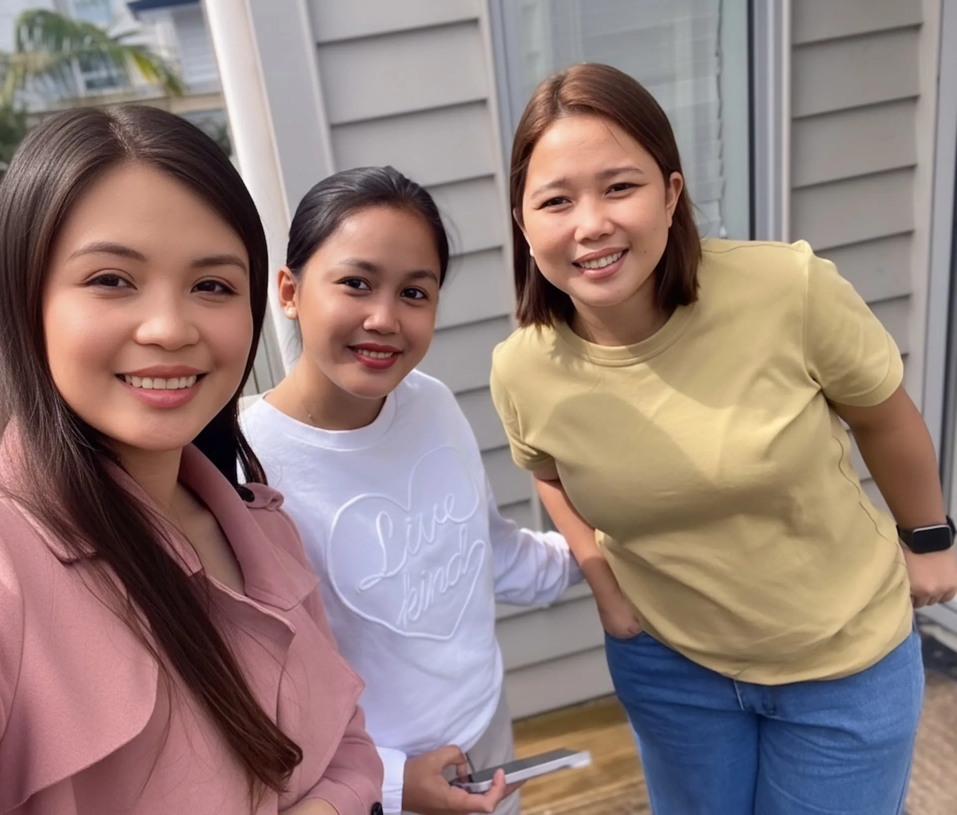 Jeanie - the founder of Jumpstart International, taking a selfie with two successful clients, happy that they are now in New Zealand.